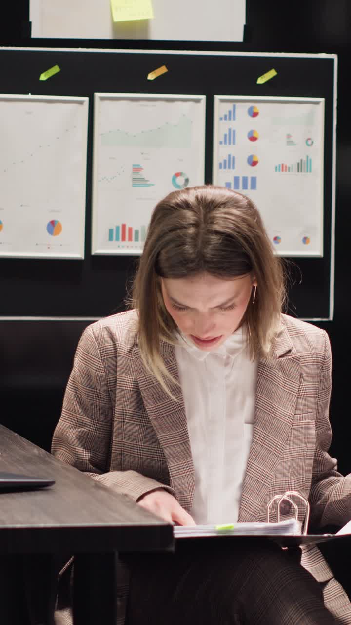 Woman working in office with business reports and charts