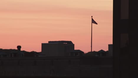 american flag swaying in the wind at sunset