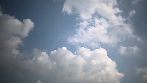 puffy fluffy white clouds slowly moving in the clear blue sky, static shot