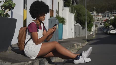 mixed race woman sitting on sidewalk