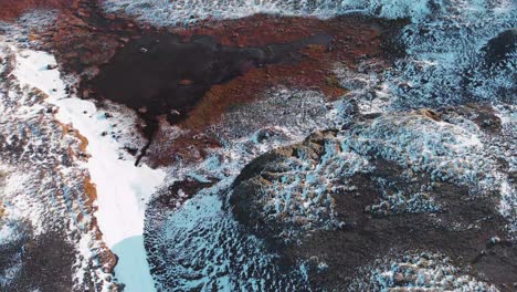 Highway road in a frozen hilly glacial landscape of Iceland from drone.