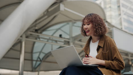 woman on video call using laptop in city
