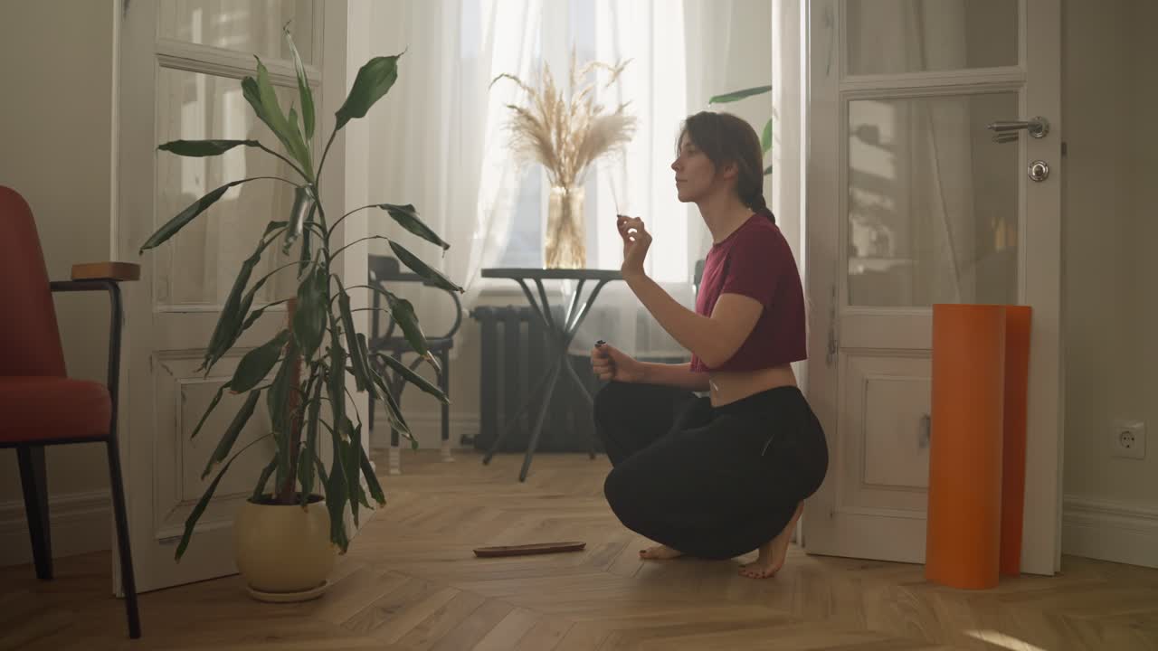 mujer meditando con incienso en casa