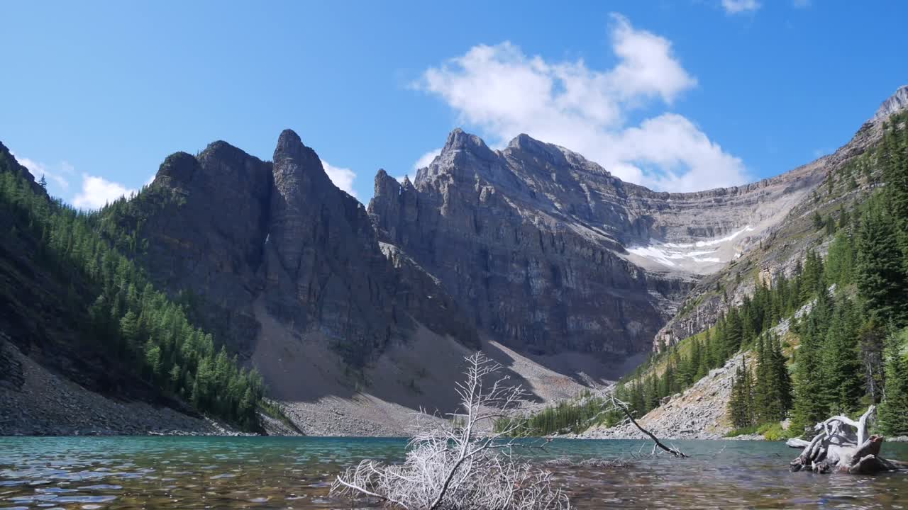 alejándose de la vista del paisaje de lapso de tiempo del lago agness en la ruta de trekking del lago louise en el día de verano con algunas nubes en la cordillera de sky-rockie con hermoso lago, alberta, canadá