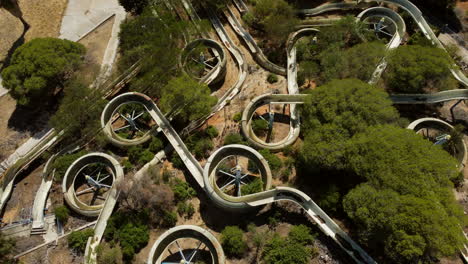 grungy water slides in an old abandoned waterpark with vegetation