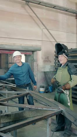 metal workers collaborating in a factory setting