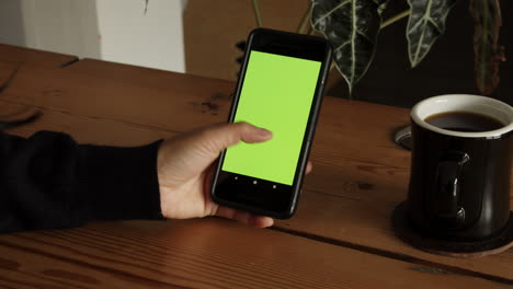 mujer deslizando el dedo en la pantalla verde y comprobando la moneda criptográfica en el mercado de valores