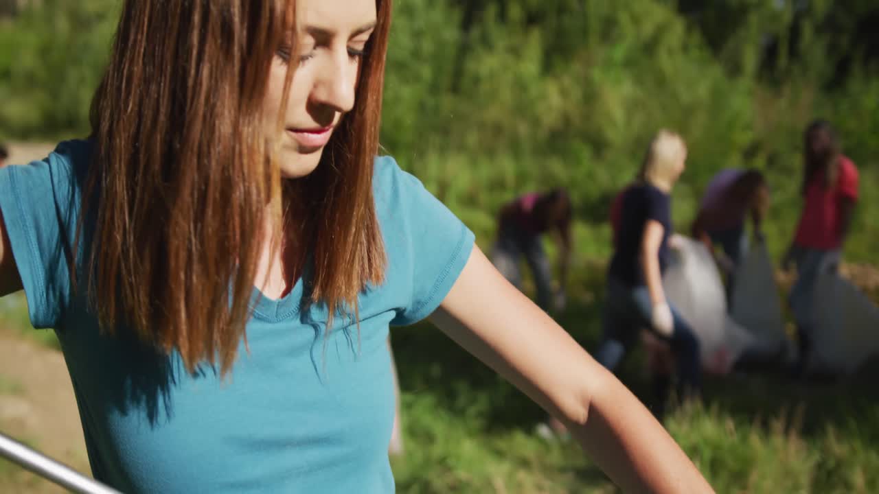mujer caucásica mirando y sonriendo a la cámara durante el día de limpieza del río
