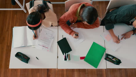 escuela, vista de arriba y estudiantes escribiendo en el aula