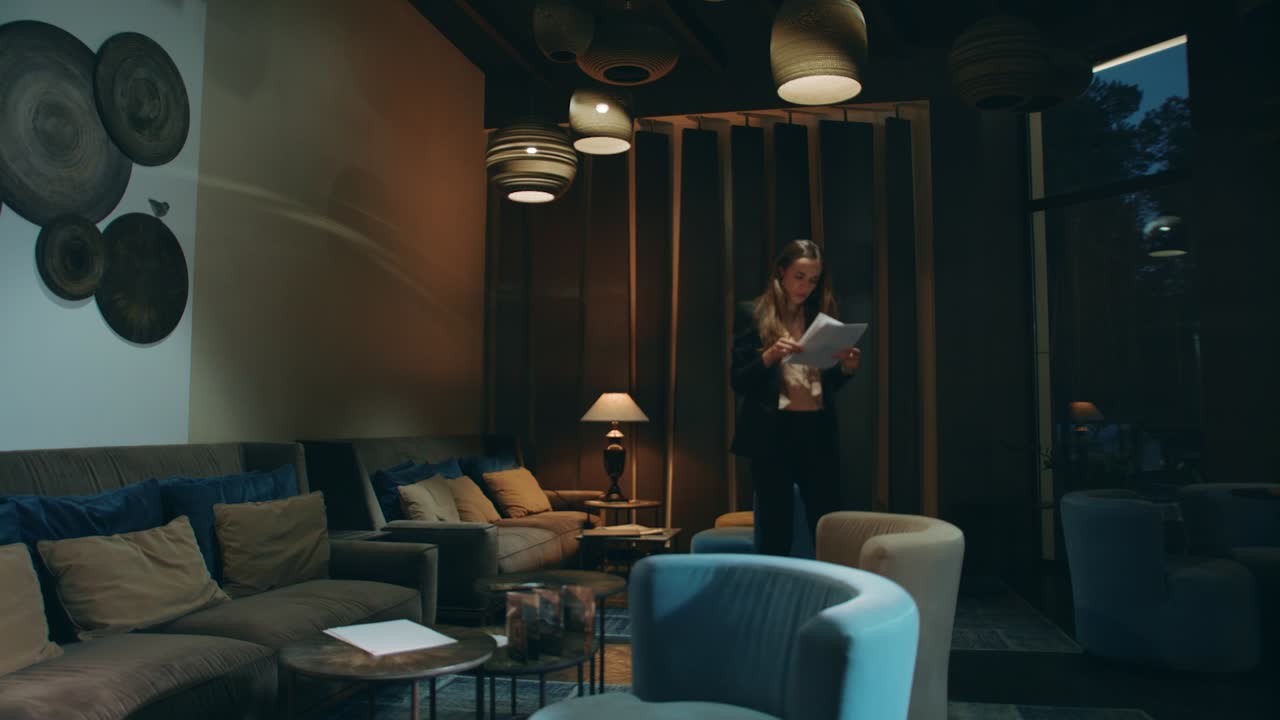 mujer de negocios preocupada leyendo un documento de negocios en el salón de la oficina por la noche