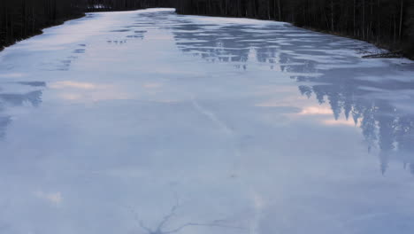 aerial drone video of icy lake with some water on the ice