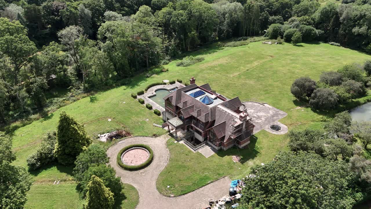 Secluded luxury celebrity real estate aerial view surrounded by lush overgrown uk woodland UK