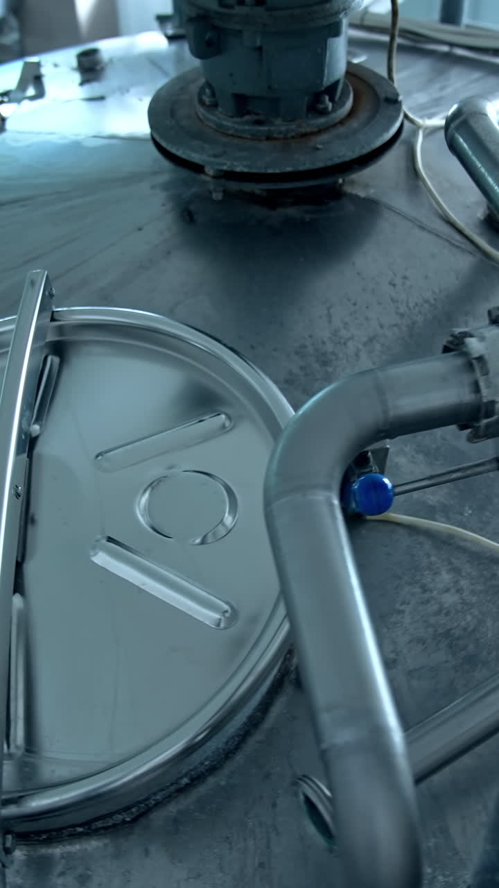 Stainless tank for milk production. Automated equipment on a milk farm. Modern industrial machinery for food processing. Top view.. Vertical video