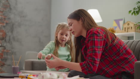 Girl-with-elder-sister-looks-at-Easter-eggs-with-marbling