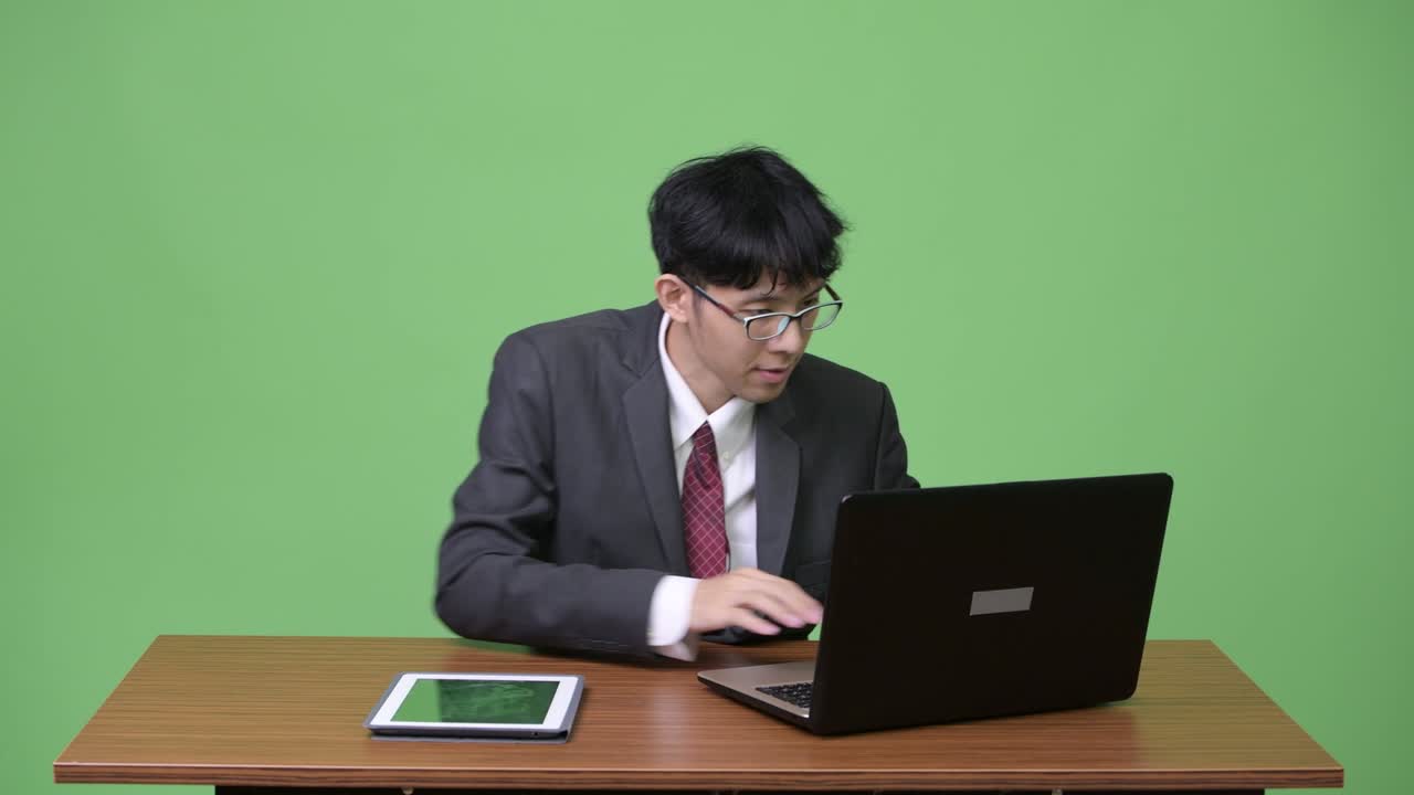 젊은 아시아 사업가 노트북과 태블릿으로 멀티 태스킹