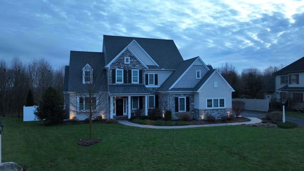Noble american mansion with large yard at dusk in winter