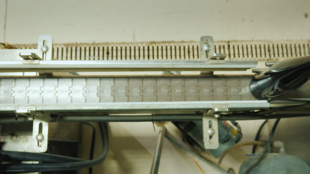 코르크 스토퍼로 닫힌 와인 병은 위에서 컨베이어 벨트 보기를 따라 이동합니다.