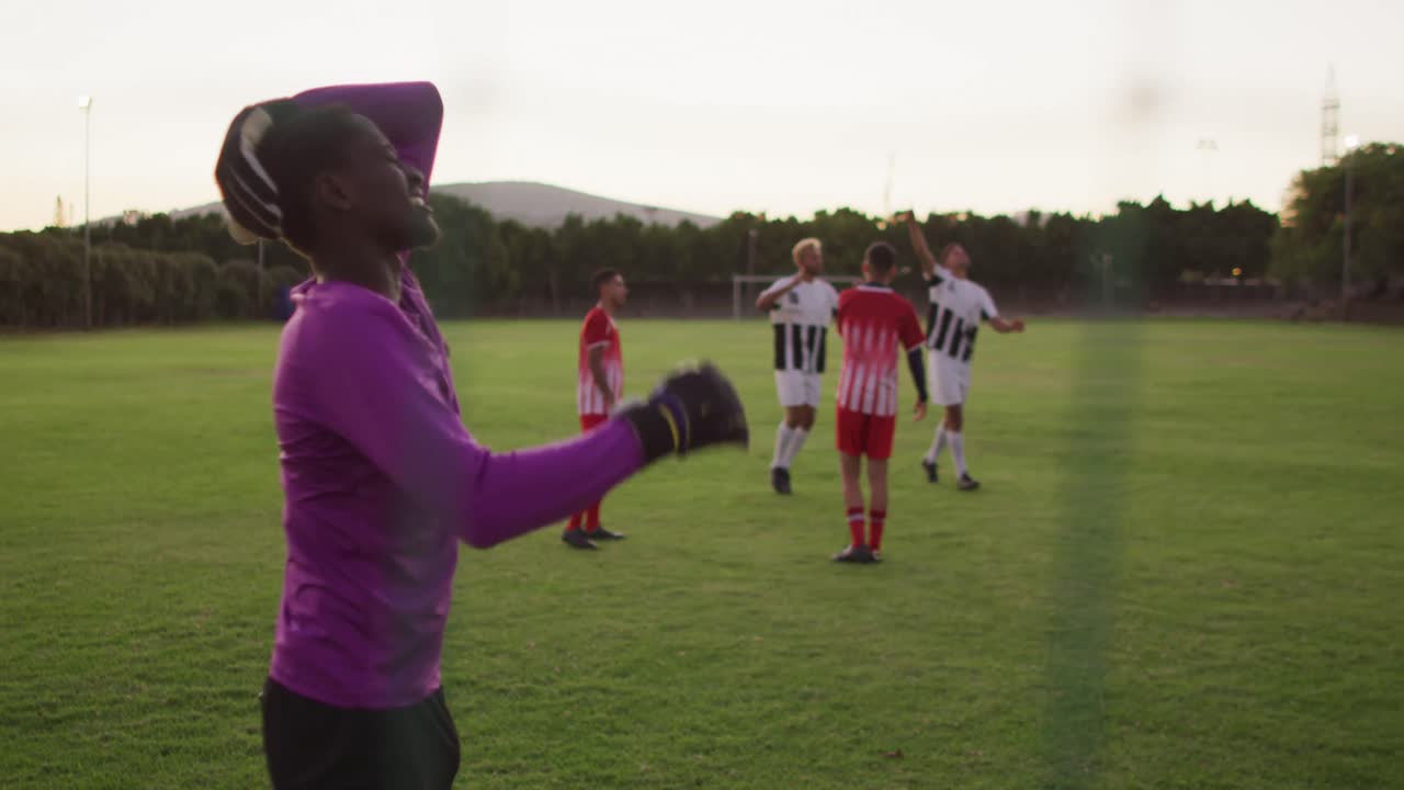 Vídeo de grupo diverso de jogadores de futebol masculinos em campo, jogando futebol