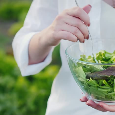 a woman in a white shirt eats fresh salad