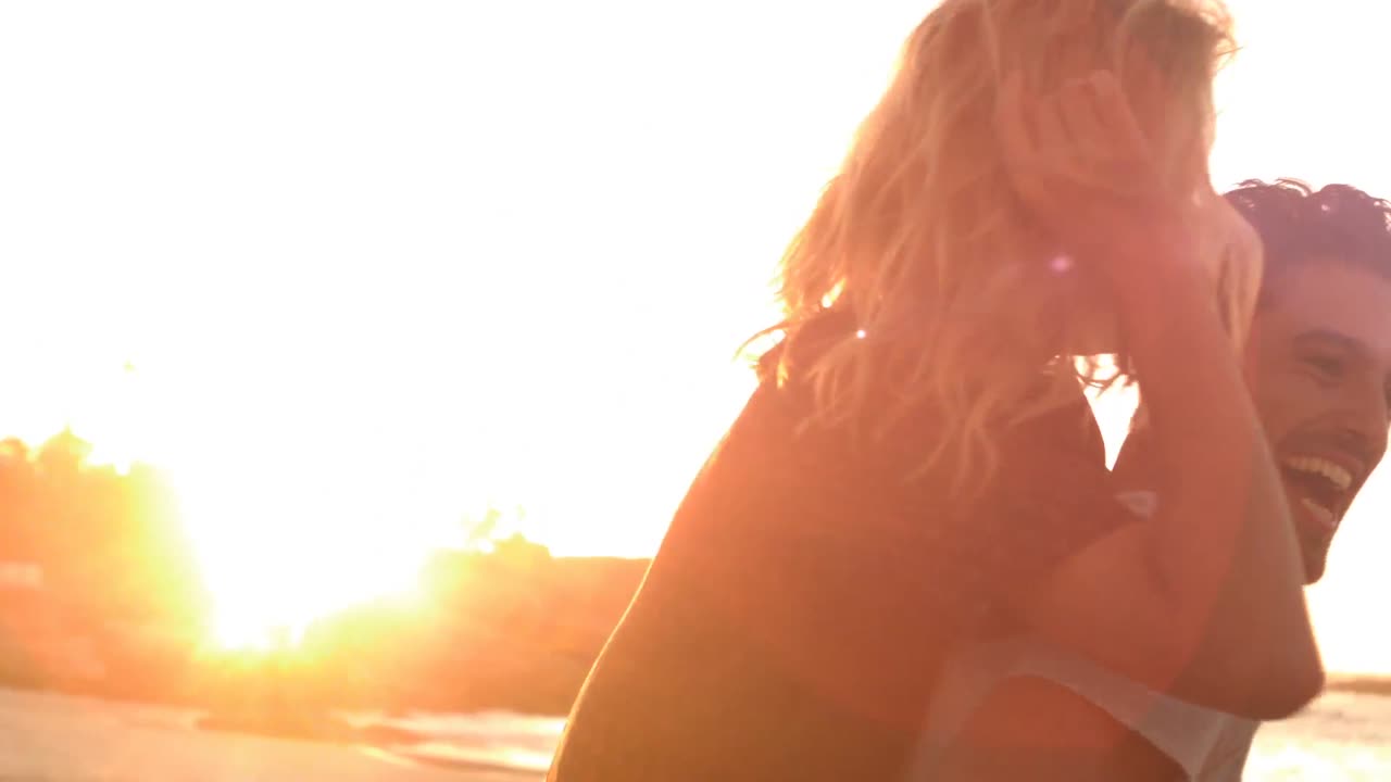 사랑에 빠진 행복한 커플. 여자가 남자의 등에 앉아 있습니다.