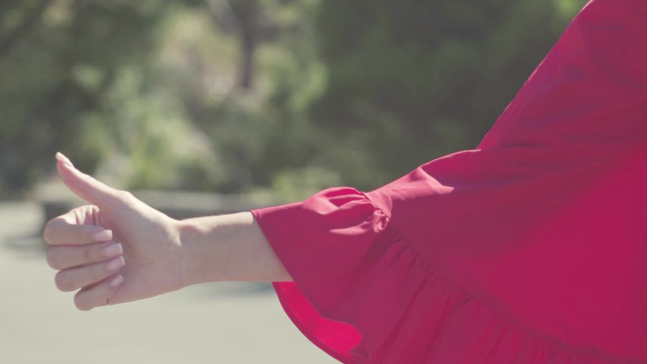 엄지손가락을 들고 몸짓을 하는 여자