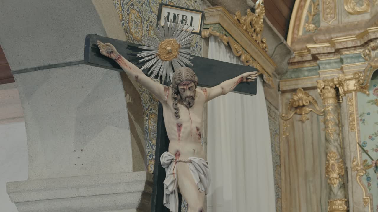 Scultura dettagliata di crocifisso su sfondo di decorazioni sfarzose dell'altare di una chiesa