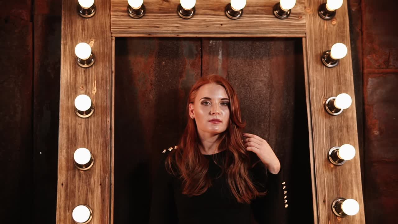 빛 을 가진 나무 거울 앞 에 검은 드레스 를 입은 여자