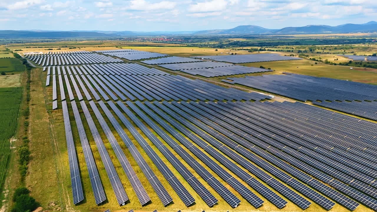 Numerous solar panels installed in the countryside. Drone footage above the fields used for green energy production
