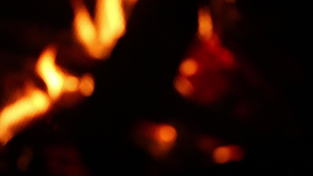 Flames engulf a wood log firewood burning in a campfire