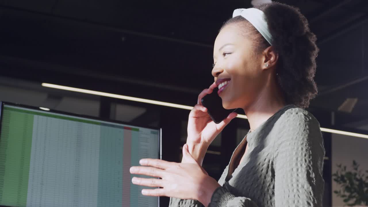 Woman speaking on phone and initiating green icons overlaying face and spreadsheet for business