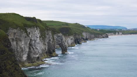 acantilados rocosos de whiterocks con olas salpicadas cerca de la ciudad de portrush en el condado de antrim, irlanda del norte durante el día