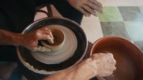 two guys use potter's wheel to create handmade clay product