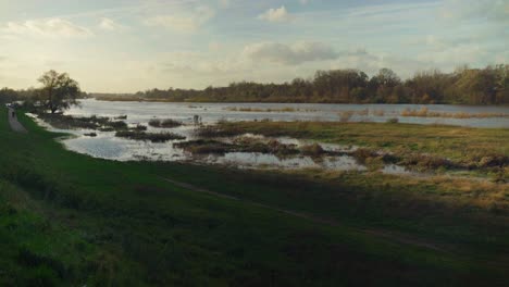 Tranquil-scenery-as-sunsets-over-peaceful-riverbank-in-the-countryside