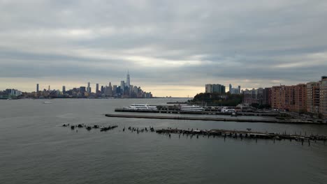 aerial drone view over docks in jersey city towards lower manhattan, in gloomy new york