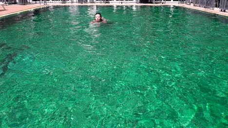 woman swims in the pool outdoors