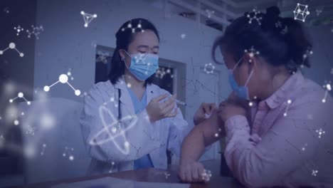 Animation-of-molecules-over-asian-doctor-and-patient