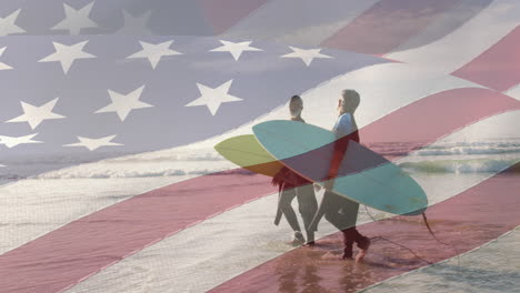 animation of american flag over senior african american couple walking on beach with surfboards