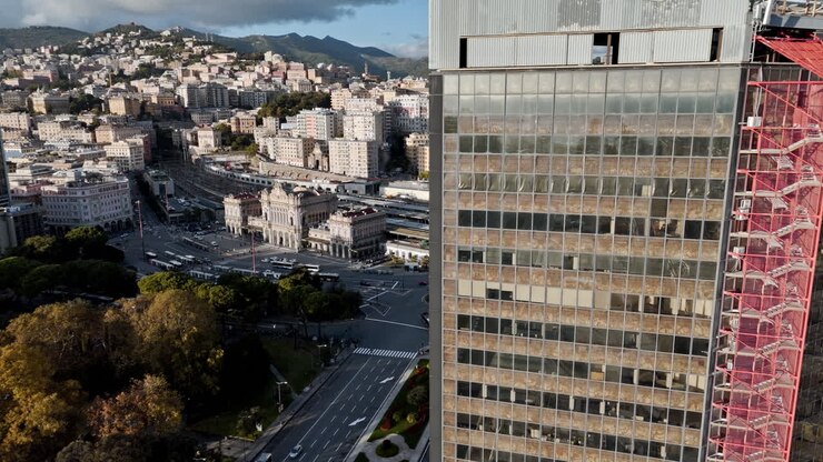 Veduta urbana della stazione di Genova Brignole e di un alto edificio.