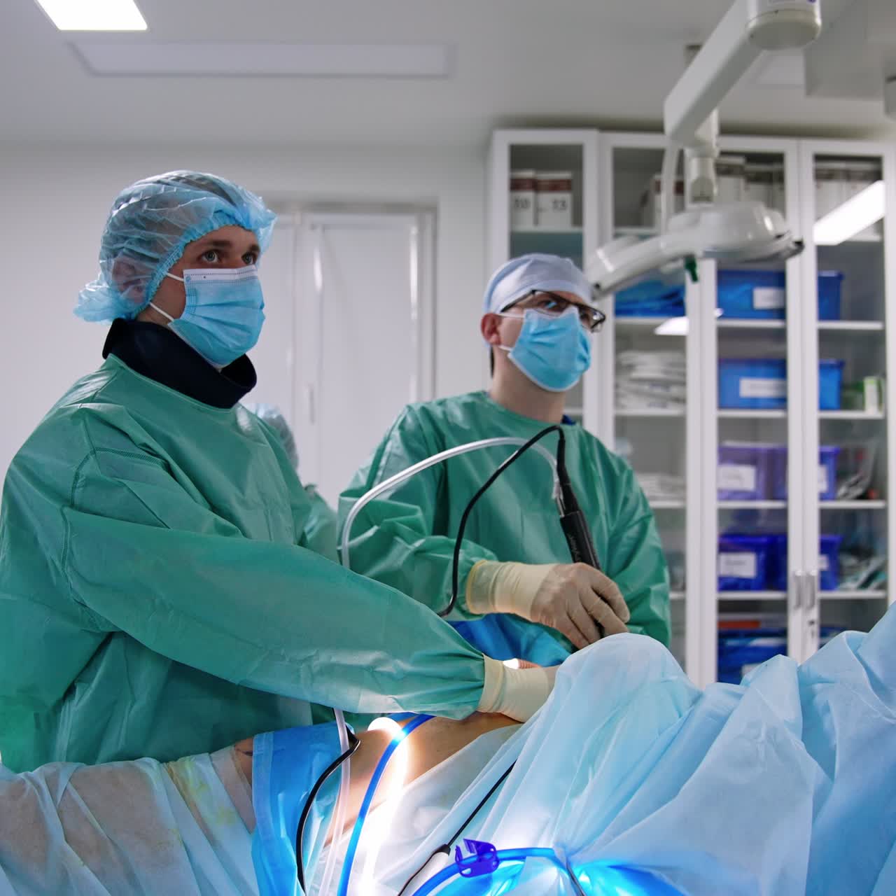 Professional surgeons use advanced laparoscopic surgical devices. Doctors are focused on the monitor in front of them