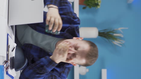 vertical video of home office worker man has tooth sensitivity.