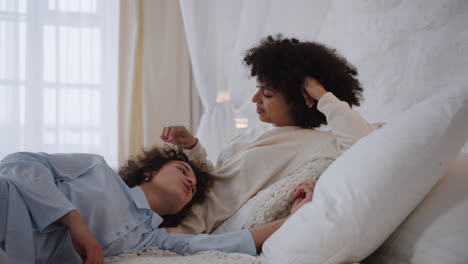 una pareja feliz hablando en la cama.