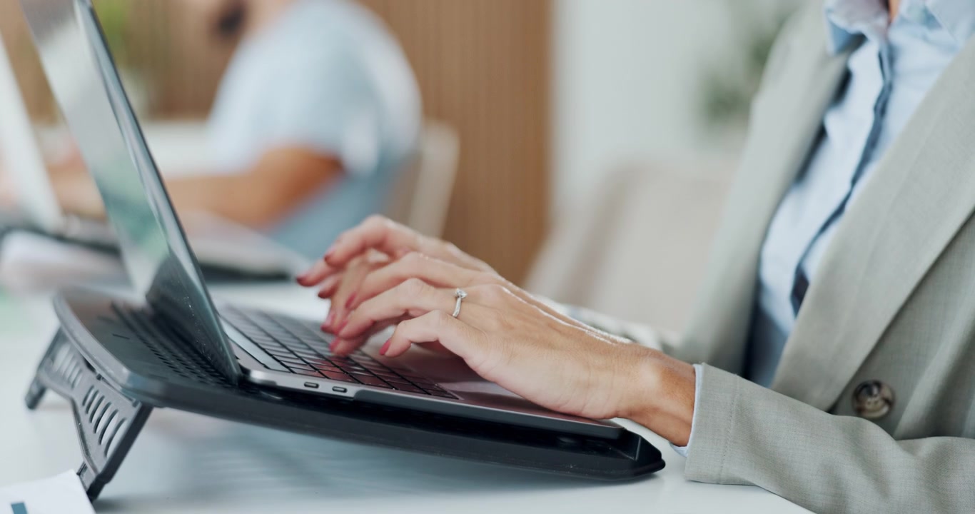 Donna d'affari che scrive sul portatile in un ufficio moderno