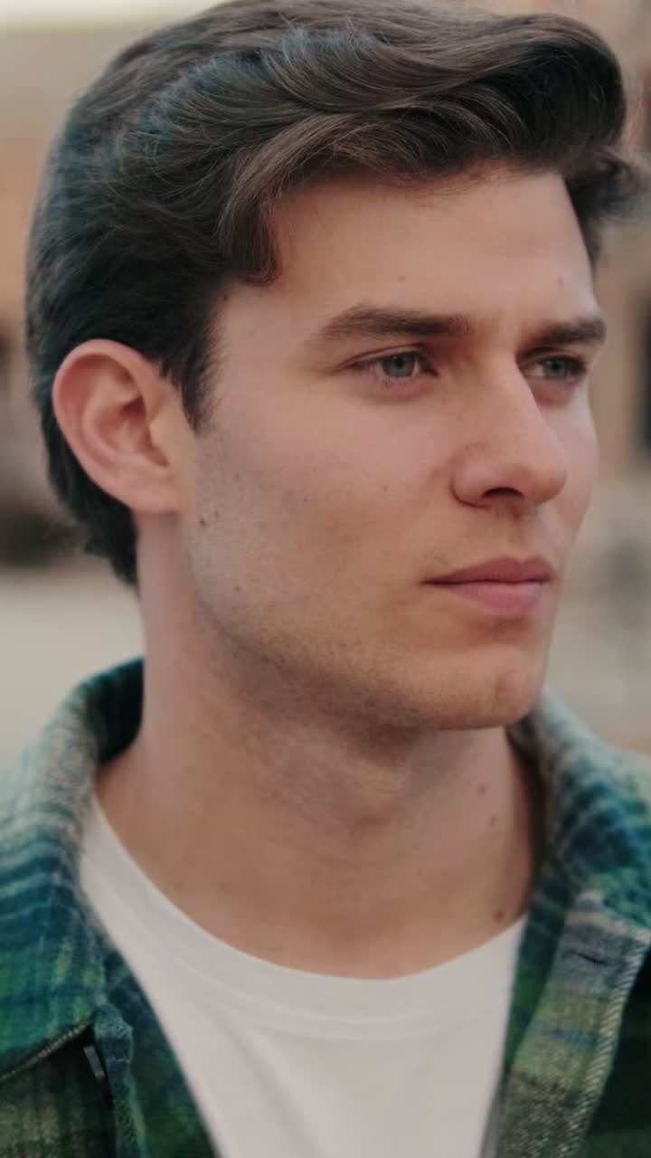 Close-up of young man looking around at an old city background
