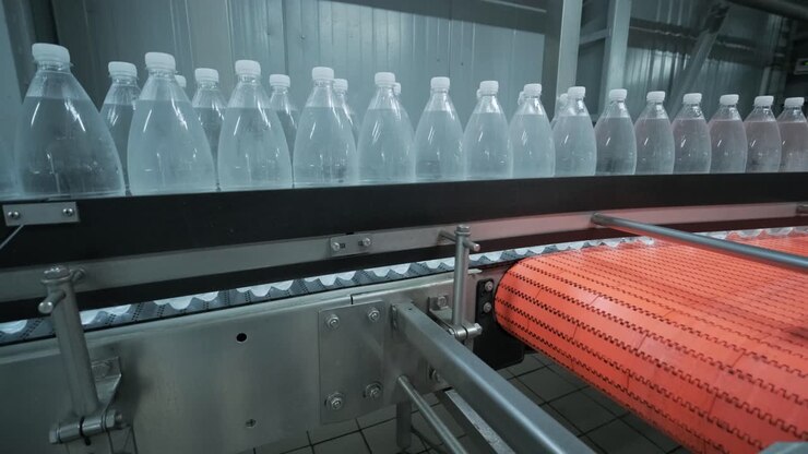 Conveyor belt with bottles of drinking water at a modern beverage plant