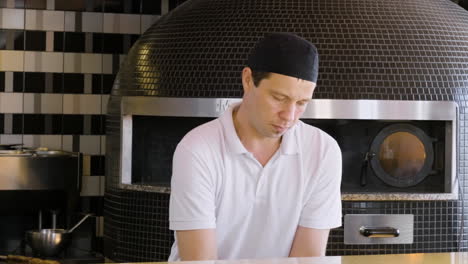 chef kneading pizza dough at restaurant