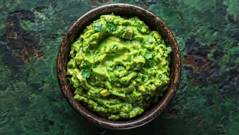 Ceramic-Bowl-Filled-With-Fresh-Guacamole-on-Green-Background