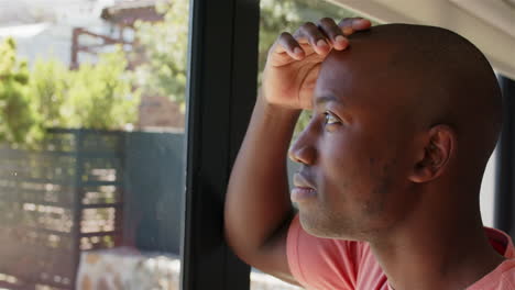 african american man looking out window, reflecting, enjoying peaceful moment, copy space