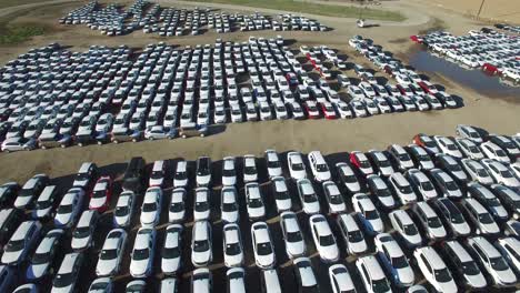 aerial perspective of new import cars sitting in a lot awaiting distribution and sale 1