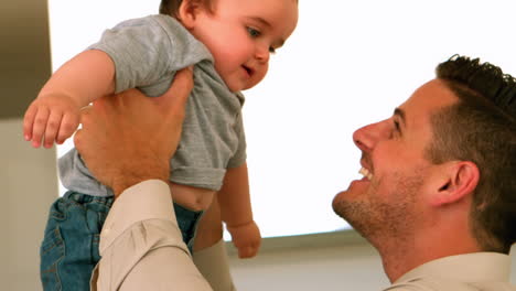padre sosteniendo a su hijo bebé antes de trabajar por la mañana