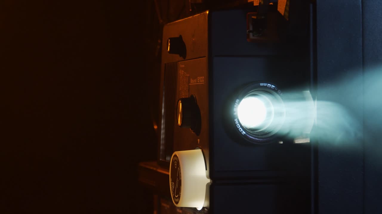 슈퍼 8 영화 프로젝터는 연기가 자욱한 방에서 오래된 홈 무비를 보여줍니다.